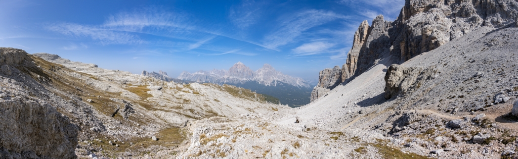Nach dem Aufstieg durch das Val Formin in der Dolomiten-Gruppe der Croda da Lago weitet sich der Blick zwischen Spiz de Mondeval (2604m), Bastiona de Mondeval (2500m) und Ponta Lastoi de Formin (2657m) auf der einen Seite und dem Cima Ambrizzola (2715m) auf der anderen Seite und gibt den Blick frei auf den Nuvolau (2574m), den Averau (2648m), den Lagazuoi (2750m), den Col dei Bos (2559m), die Gruppe der Fanes mit den Fanesspitzen, die Tofana di Rozes (3225m) und  Tofana di Mezzo (3244m), Dolomiten, Südtirol, September 2023.
